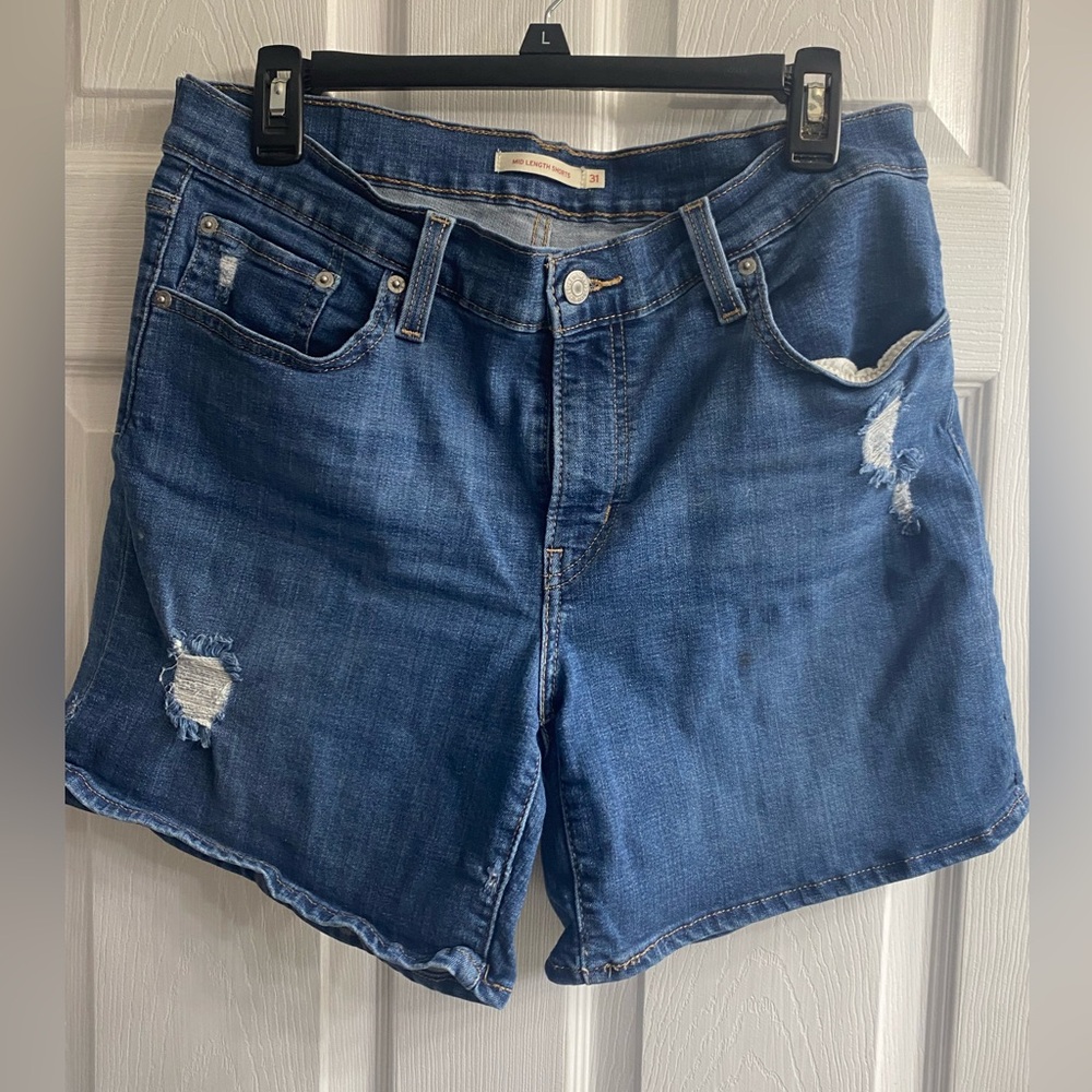 Levi Mid length distressed blue denim shorts.   Size 31 waist